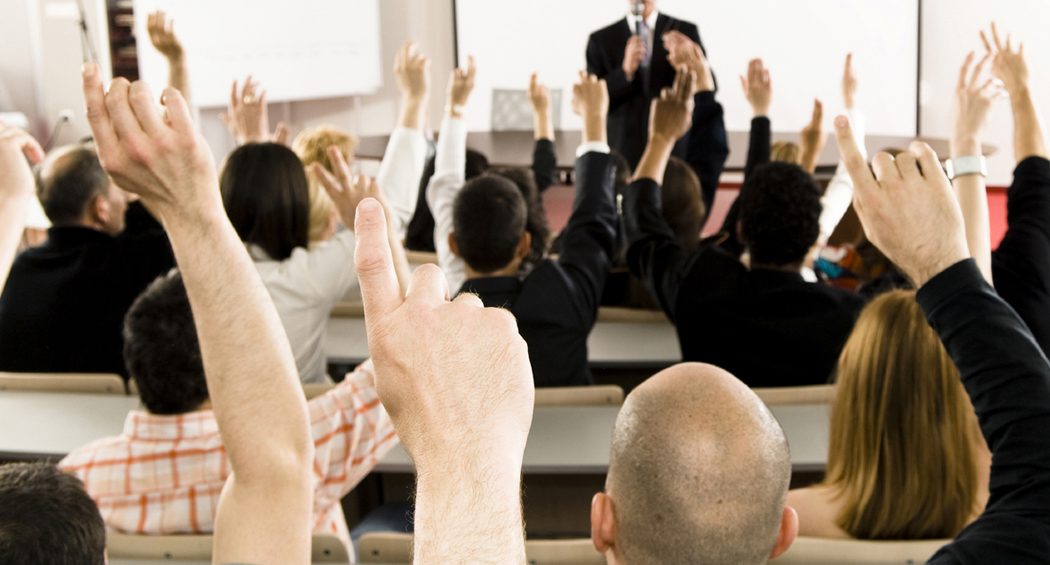 FAQs Classroom of professionals raising their hand